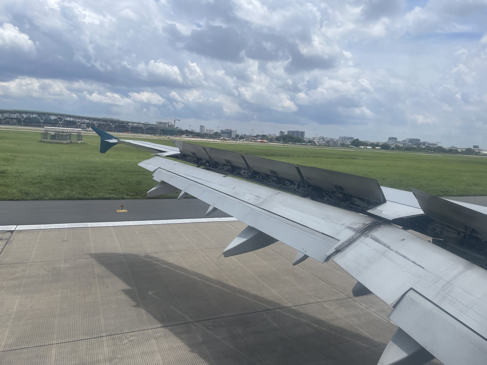 着陸したばかりの機内の窓から見たタンソンニャット空港の滑走路と芝生