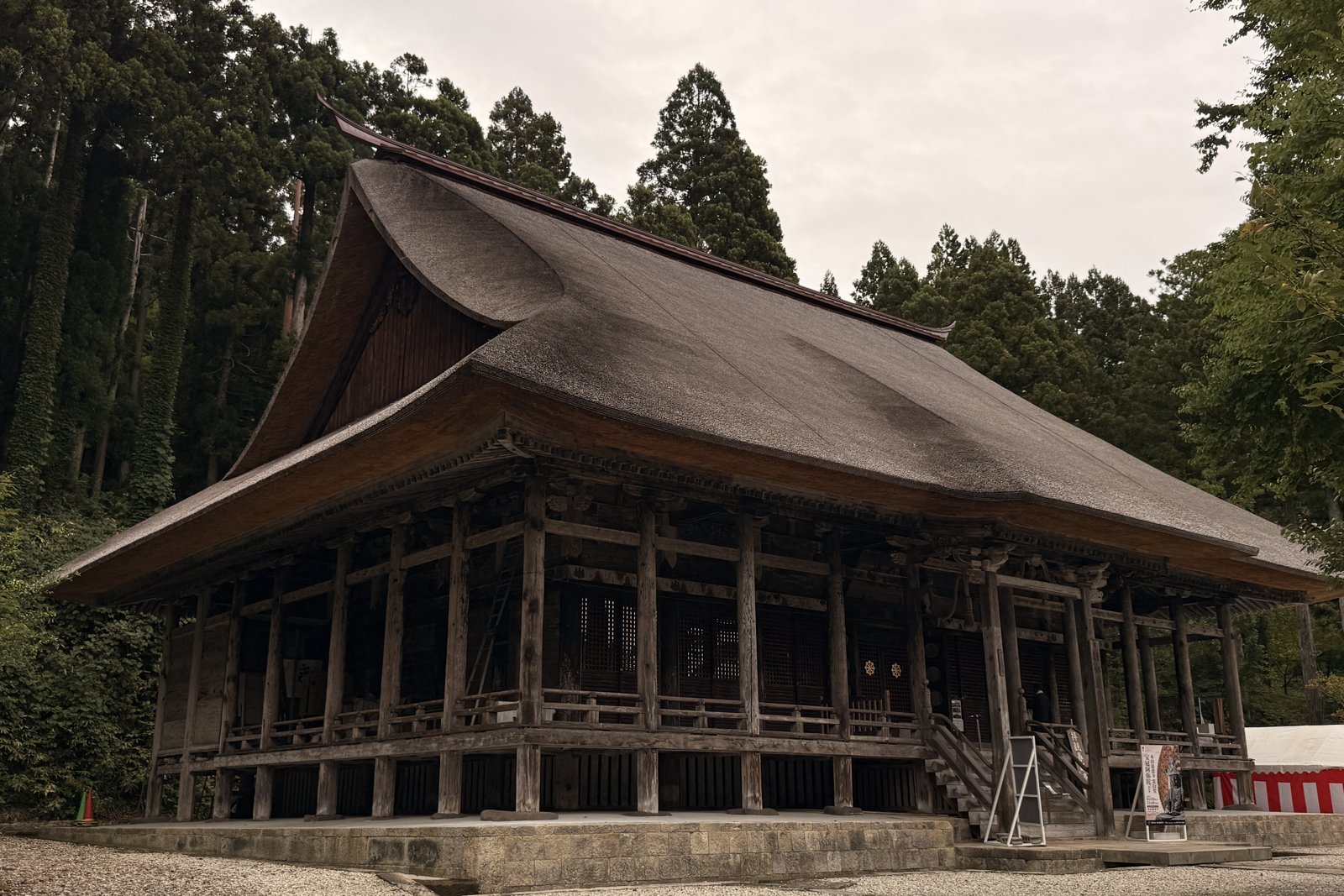 慈恩寺の本堂、大きなかやぶき屋根と杉木立